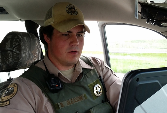FWP Game warden working at a computer in his vehicle