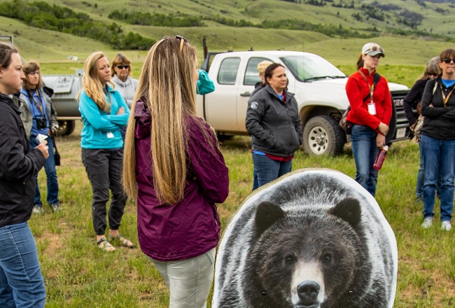 Folks standing outside listening to FWP employee talk about bear awarness.