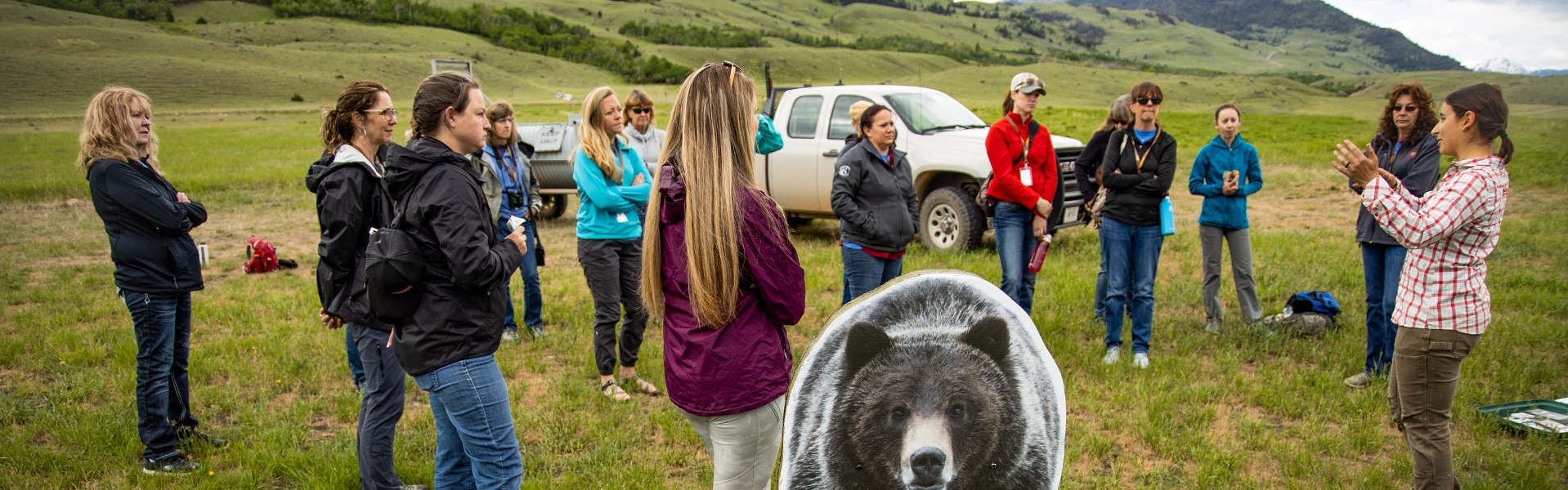 Group of people outdoors listening during a bear safety presentation.