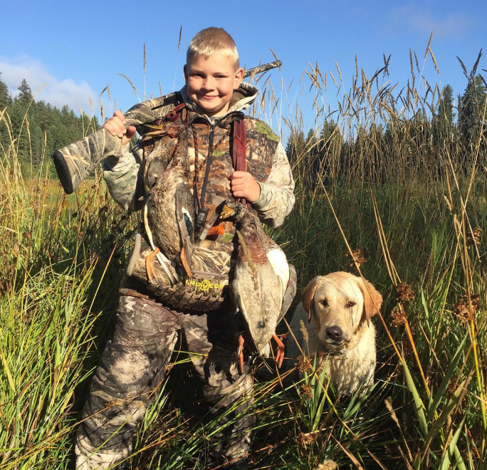 Youth hunter with duck and dog