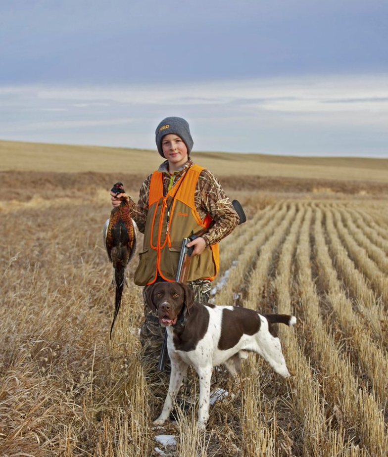 Youth with pheasant and hunting dog