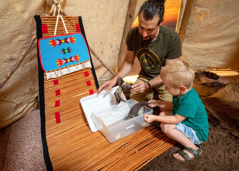 Man and child in tipi at Chief Plenty Coups State Park