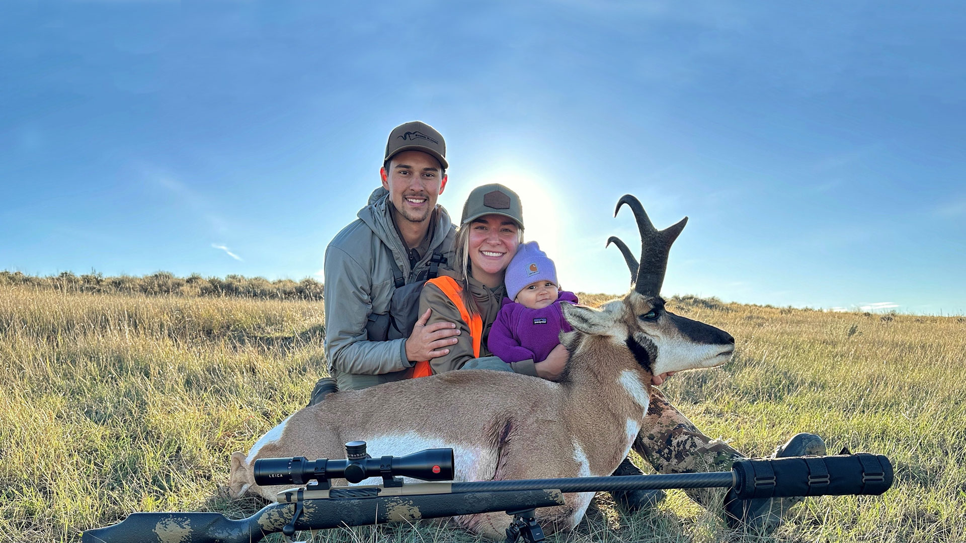 Smiling family with small child and pronghorn harvest