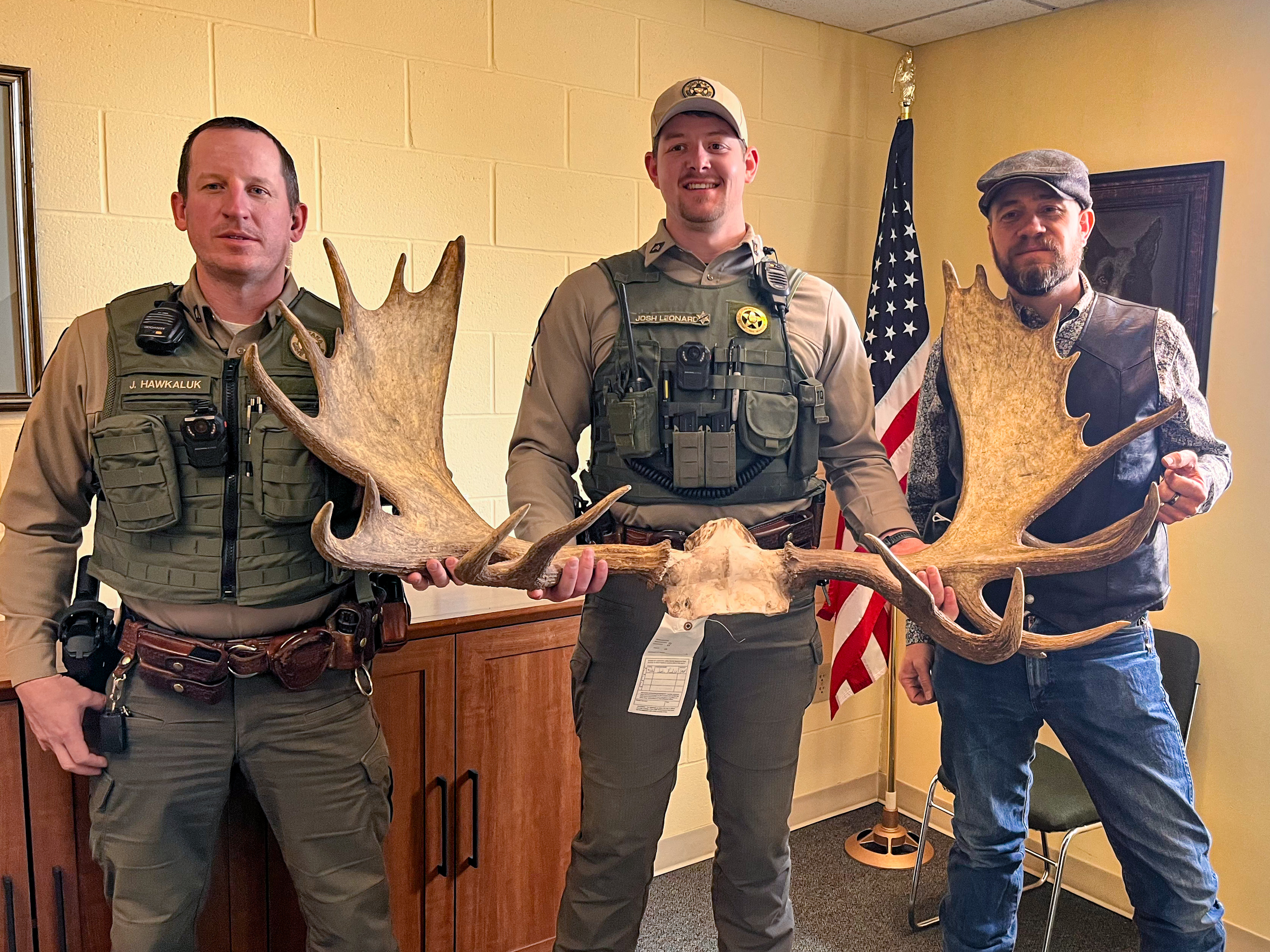 Game wardens with moose skull