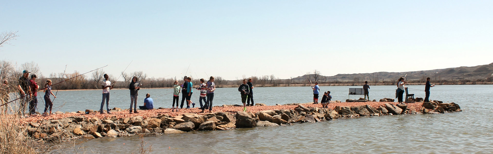 Lots of anglers fishing at community pond.