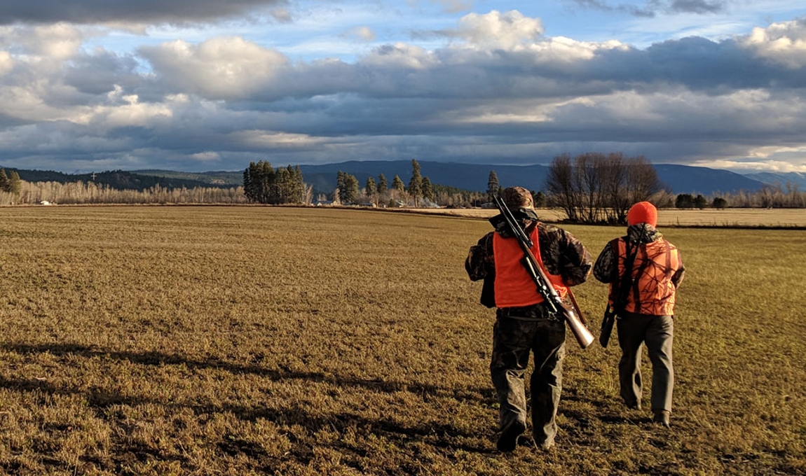 Photo of two hunters walking in a field